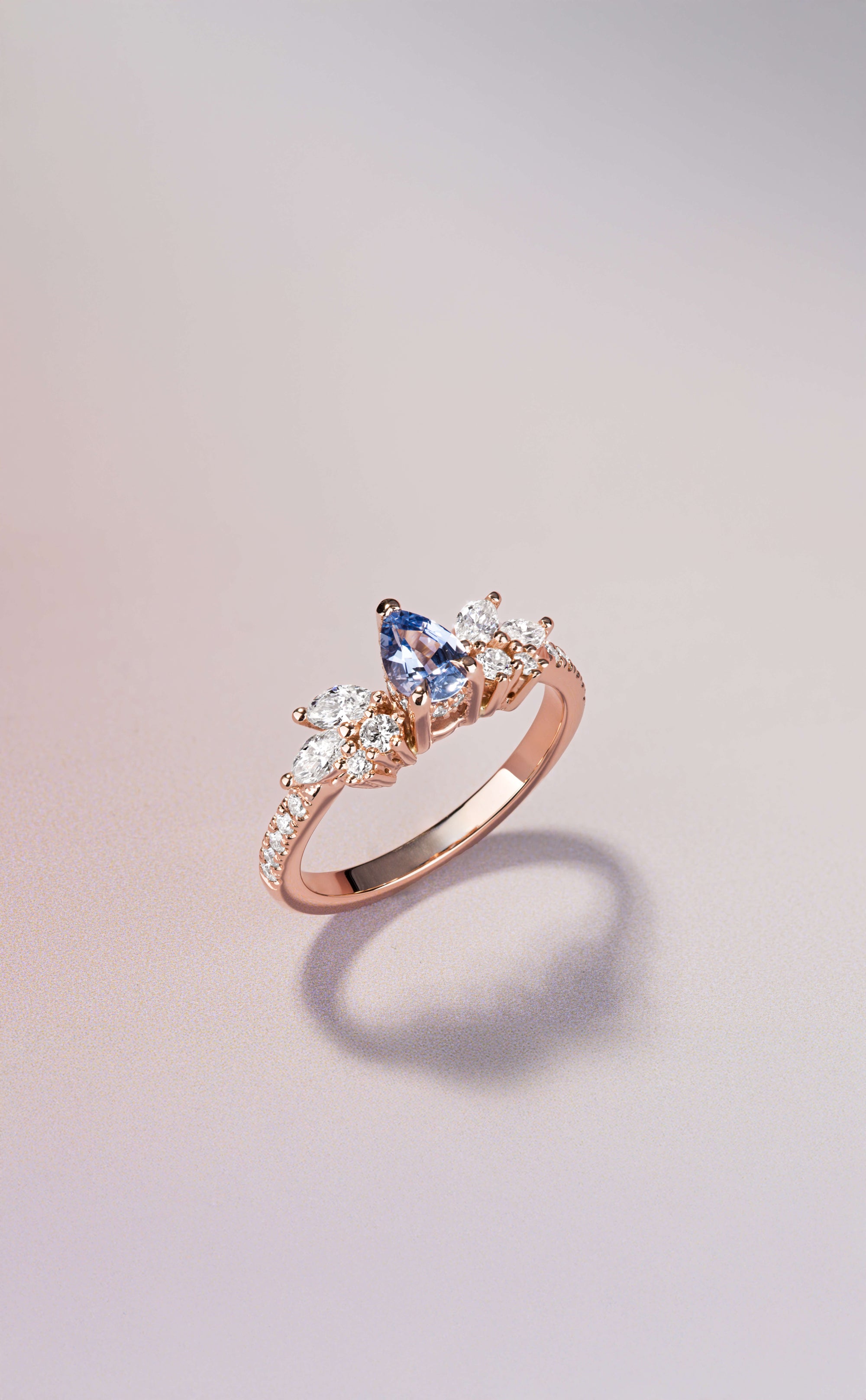 Canadian-made engagement ring with a pear sapphire and diamond cluster set in 14K rose gold.
