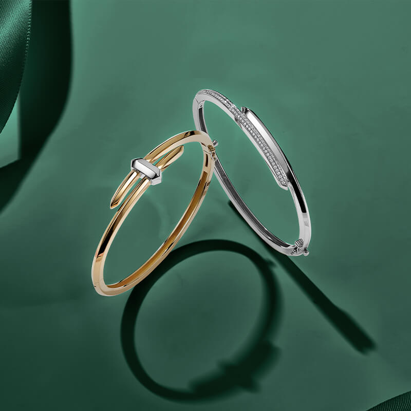 ecksand yellow gold and white gold bangles with diamond accents on green background