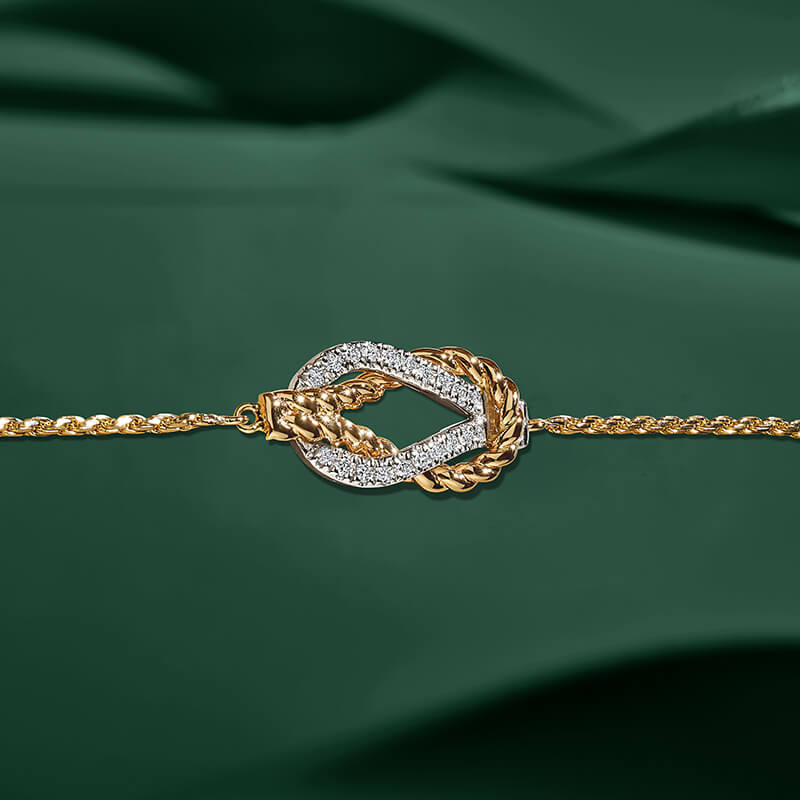 ecksand white and yellow gold twisted chain bracelet with diamond accents on green background