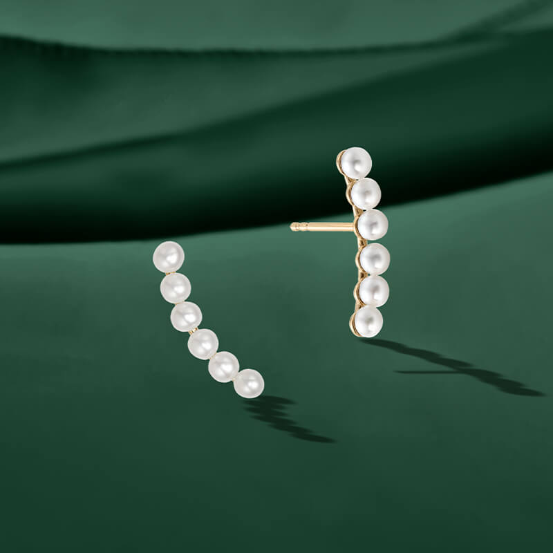 ecksand yellow gold pearl bridal earrings on green background