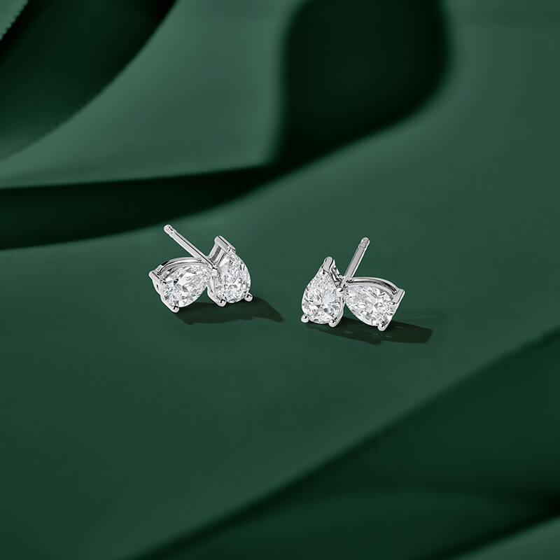 ecksand white gold two stone earrings with diamonds on green background