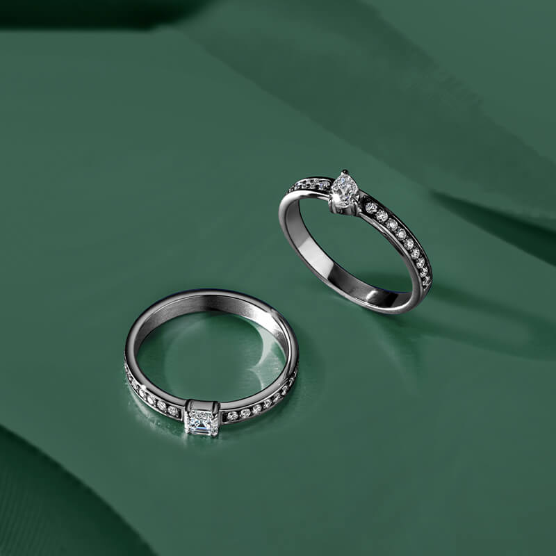 ecksand white gold diamond rings with blackened gold on green background