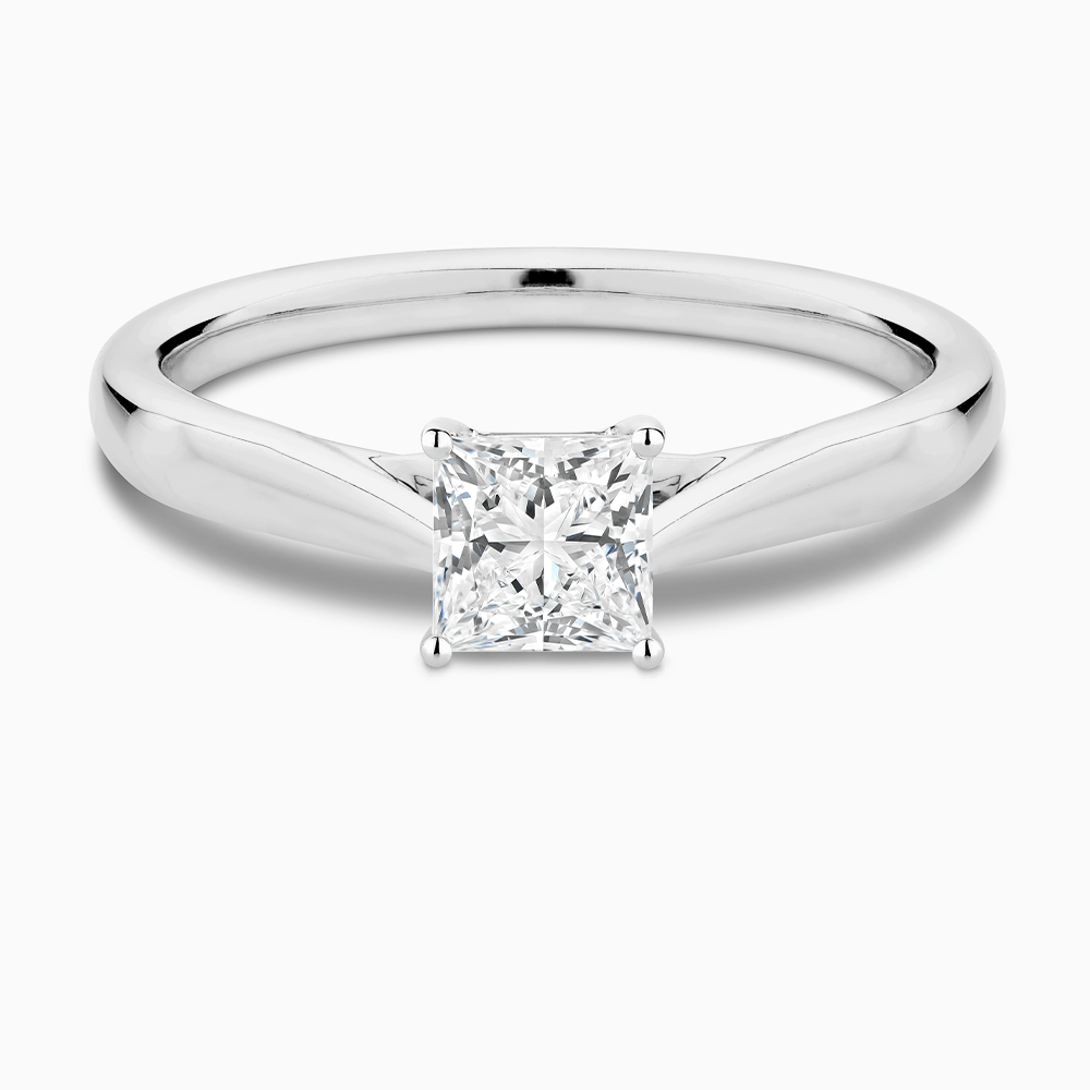The Ecksand Iconic Tapered Band Solitaire Diamond Engagement Ring with Secret Heart shown with Princess in 18k White Gold