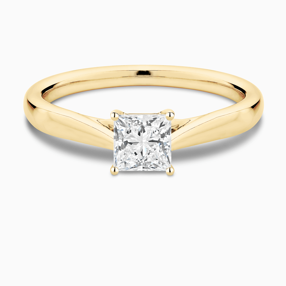 The Ecksand Iconic Tapered Band Solitaire Diamond Engagement Ring with Secret Heart shown with Princess in 18k Yellow Gold