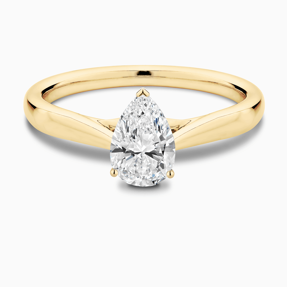 The Ecksand Iconic Tapered Band Solitaire Diamond Engagement Ring with Secret Heart shown with Pear in 18k Yellow Gold