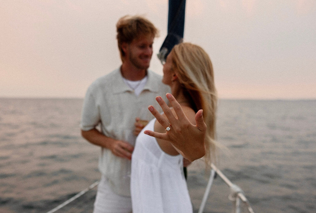 A couple getting engaged on a boat with an Ecksand engagement ring