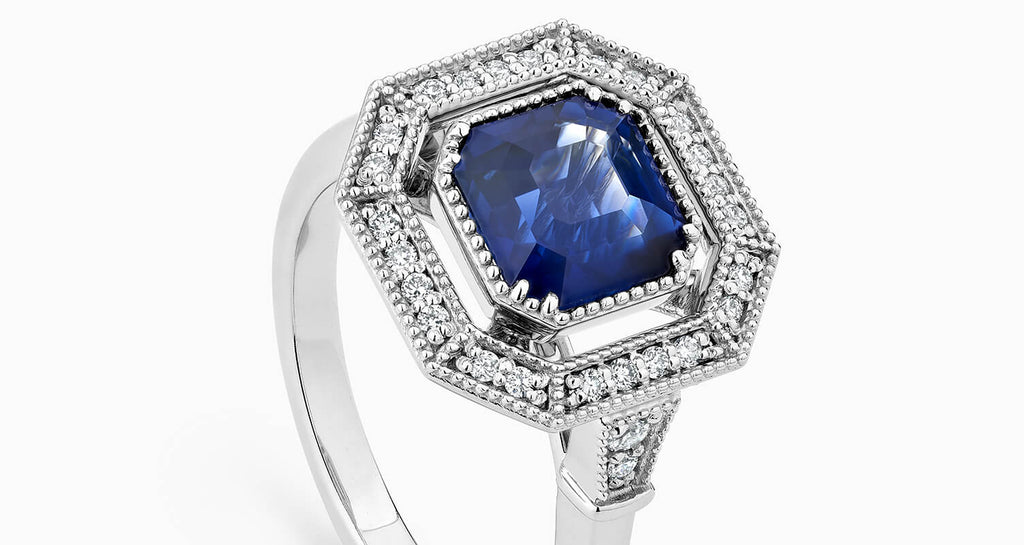 Canadian-made sapphire engagement ring with a hexagonal diamond halo set in 18K white gold.