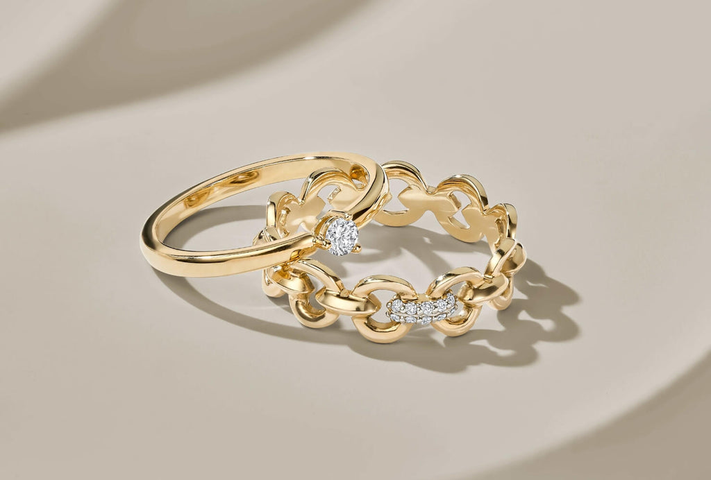 Front-facing photo of a solitaire engagement ring and a duel ring.