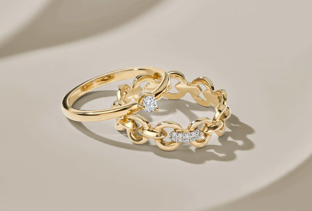 A Canadian-made diamond engagement ring and chain-link wedding ring in 18K yellow gold.