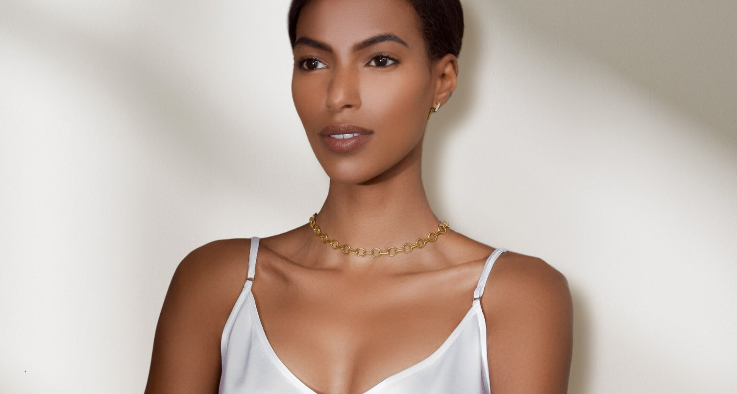 ecksand gold necklace on model on gray background