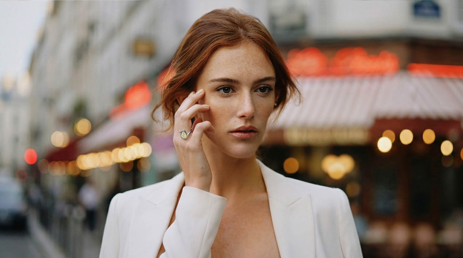 Model wearing a canadian-made 18k white and yellow gold pear cut yellow diamond engagement ring in a white blazer in paris