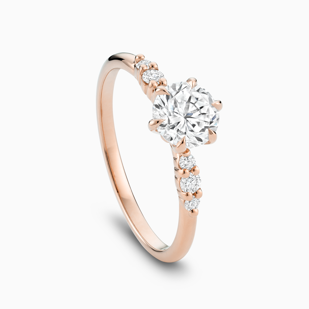 Angled view of Ecksand's Engagement Ring with Eagle Prongs and Side Diamonds in 14k Rose Gold, Round