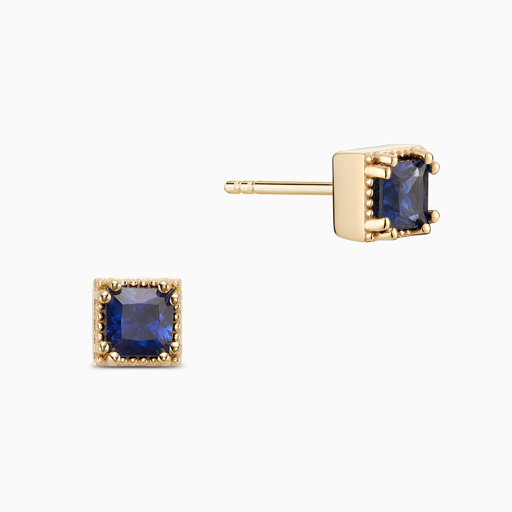 Face view of Ecksand's Princess Blue Sapphire Stud Earrings with Milgrain Halo in 18k Yellow Gold