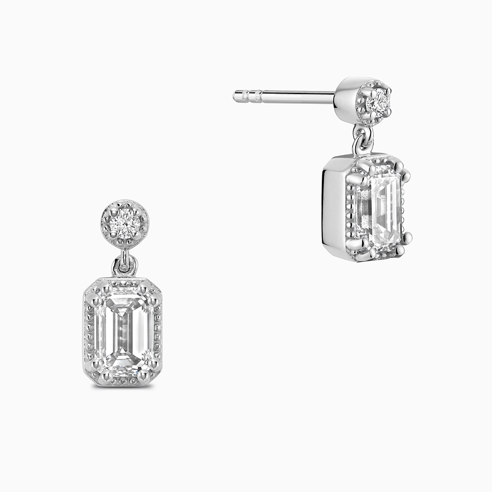 Face view of Ecksand's Emerald Diamond Stud Earrings with Milgrain Halo and Diamond Accent in 18k White Gold, Lab-grown VS2+/ F+