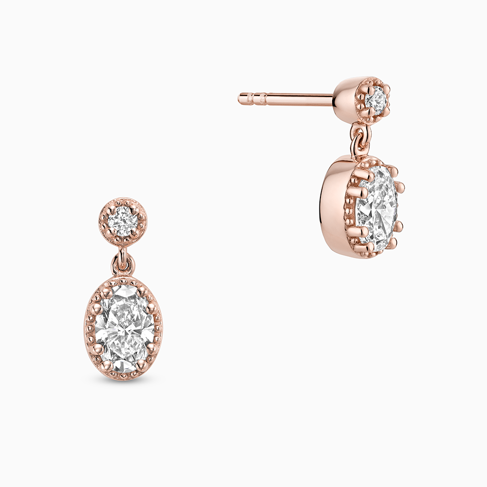 Face view of Ecksand's Oval Diamond Stud Earrings with Milgrain Halo and Diamond Accent in 18k Rose Gold, Lab-grown VS2+/ F+