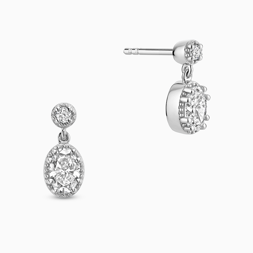 Face view of Ecksand's Oval Diamond Stud Earrings with Milgrain Halo and Diamond Accent in 18k White Gold, Lab-grown VS2+/ F+