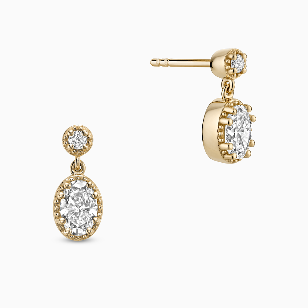 Face view of Ecksand's Oval Diamond Stud Earrings with Milgrain Halo and Diamond Accent in 18k Yellow Gold, Lab-grown VS2+/ F+