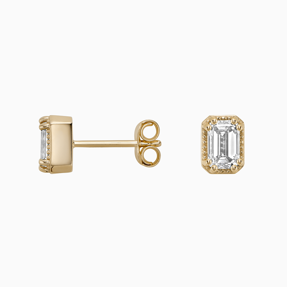 Angled view of Ecksand's Emerald Diamond Stud Earrings with Milgrain Halo in 18k Yellow Gold, Lab-grown VS2+/ F+