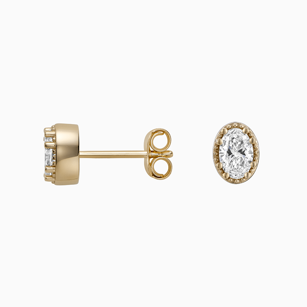 Angled view of Ecksand's Oval Diamond Stud Earrings with Milgrain Halo in 18k Yellow Gold, Lab-grown VS2+/ F+