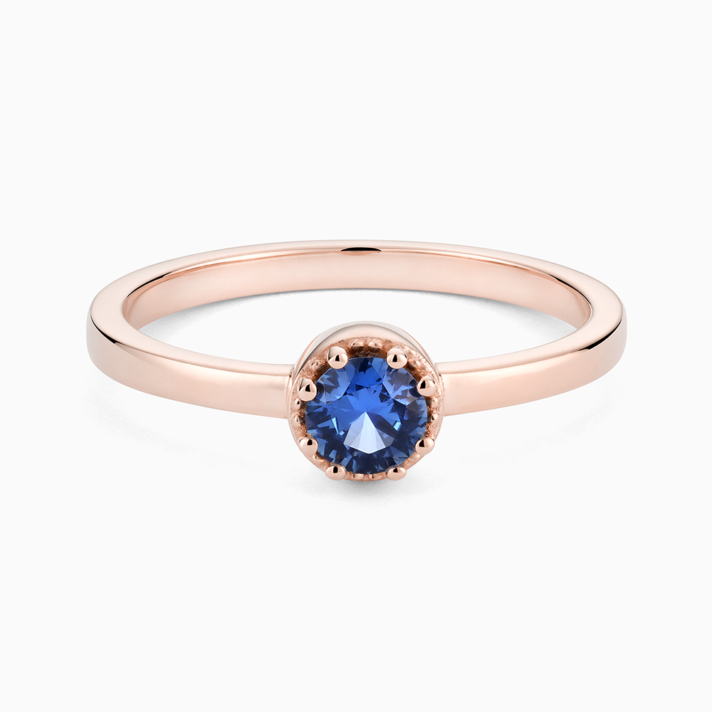 Face view of Ecksand's Round Blue Sapphire Stackable Ring with Milgrain Halo in 18k Rose Gold