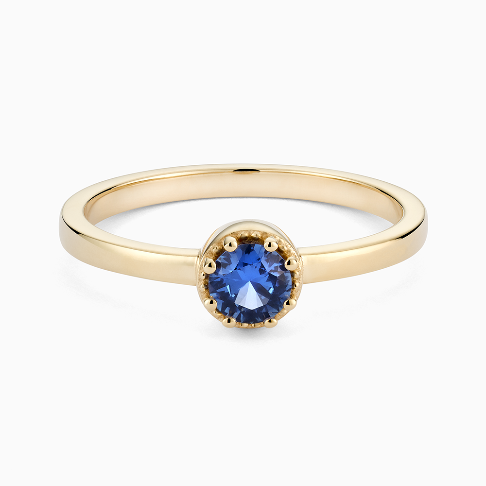 Face view of Ecksand's Round Blue Sapphire Stackable Ring with Milgrain Halo in 18k Yellow Gold