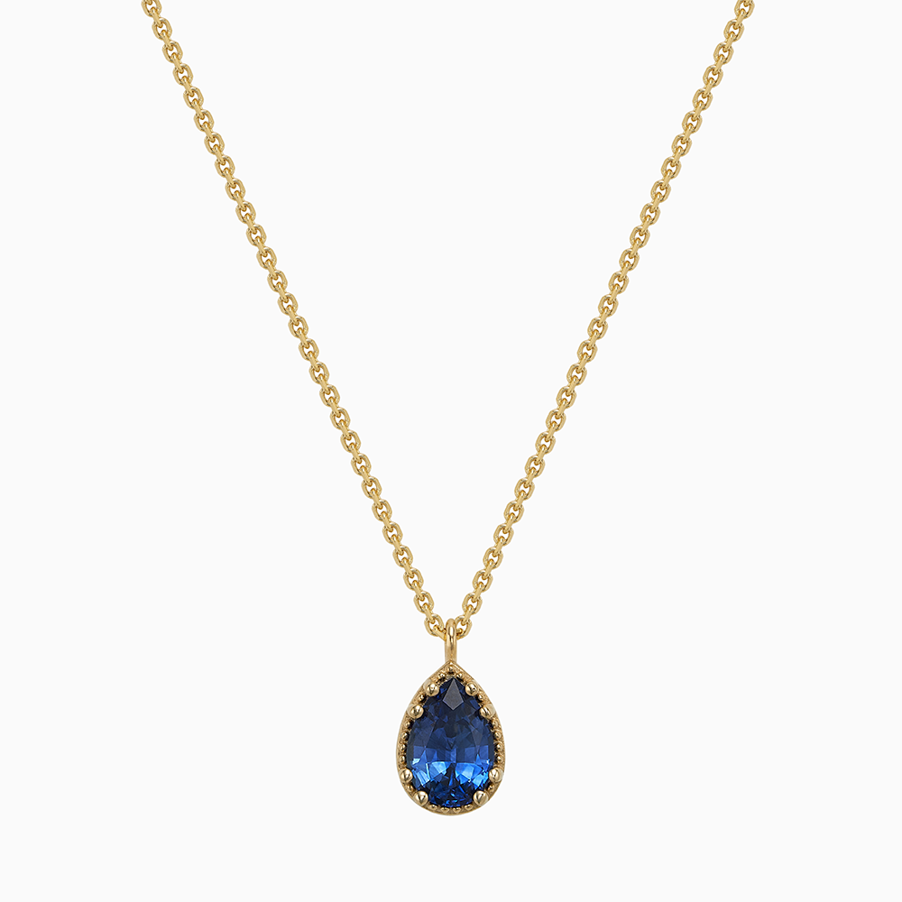 Face view of Ecksand's Pear Blue Sapphire Stackable Necklace with Milgrain Halo in 18k Yellow Gold