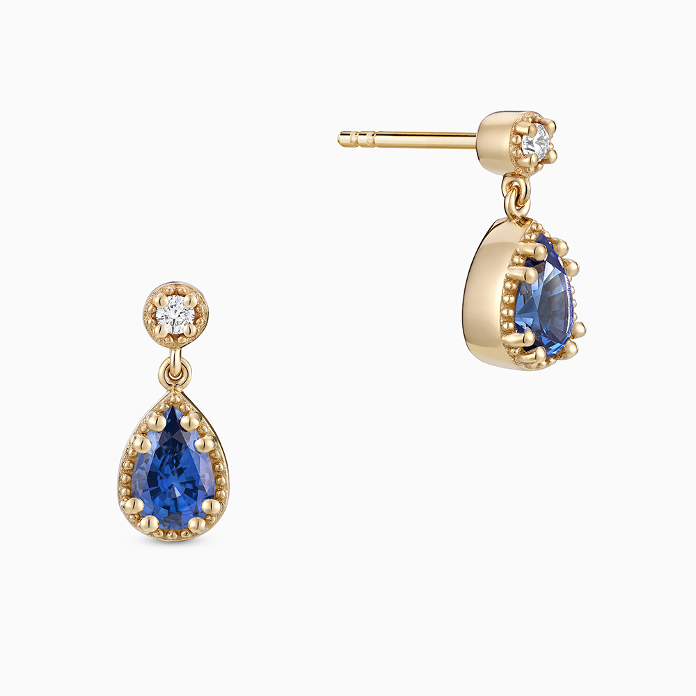 Face view of Ecksand's Pear Blue Sapphire Stud Earrings with Milgrain Halo and Diamond Accent in 18k Yellow Gold, Lab-grown VS2+/ F+