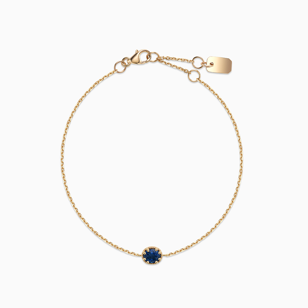 Face view of Ecksand's Oval Blue Sapphire Stackable Bracelet with Milgrain Halo in 18k Yellow Gold