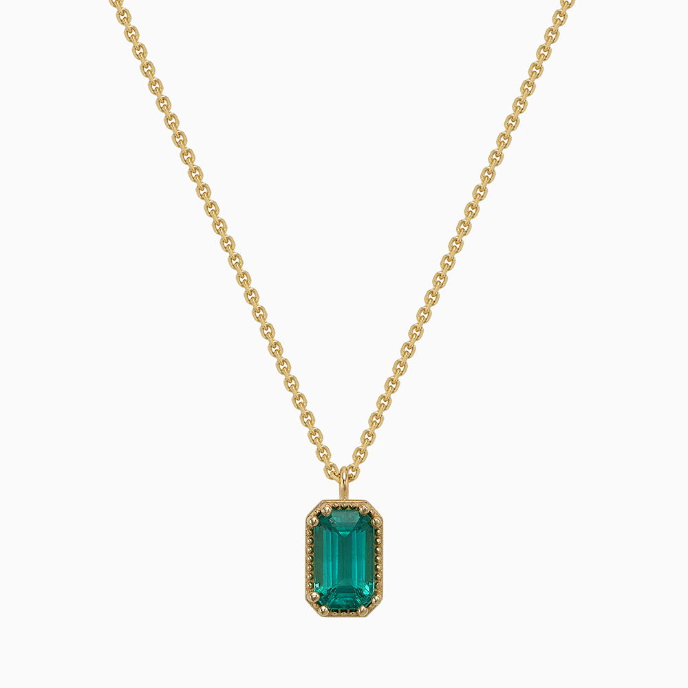 Face view of Ecksand's Emerald Stackable Necklace with Milgrain Halo in 14k Yellow Gold