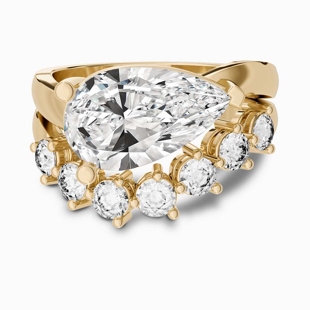 Canadian-made Ecksand bridal set with a pear-cut diamond engagement ring and matching wedding band in 18K yellow gold.