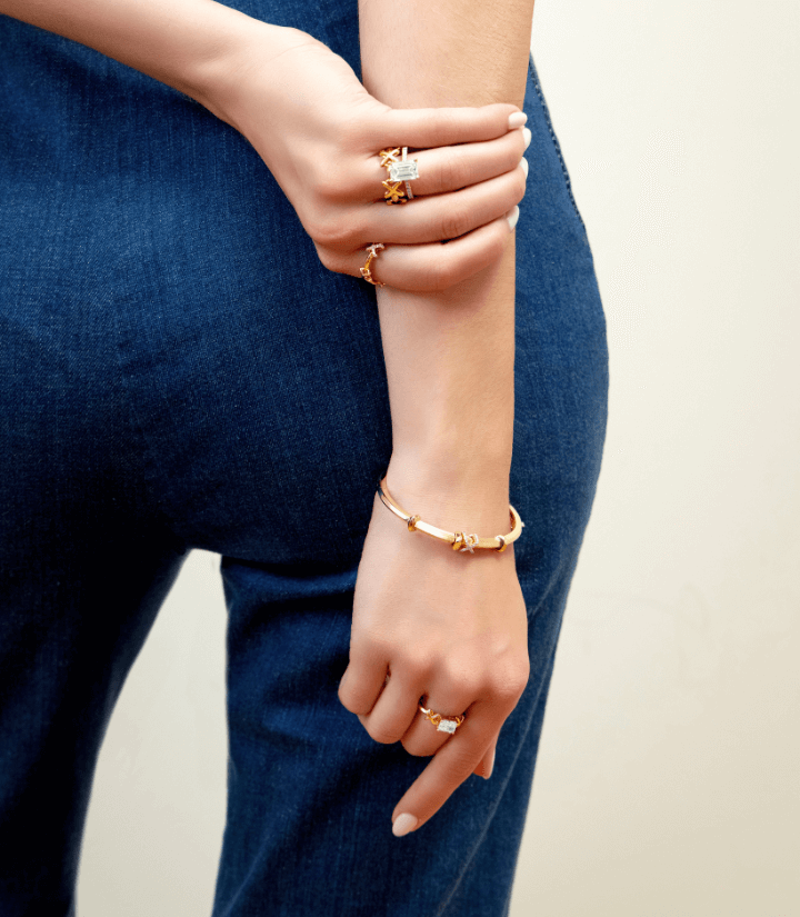 Model wearing Canadian-made Ecksand gold bangles and rings in rose and yellow gold.