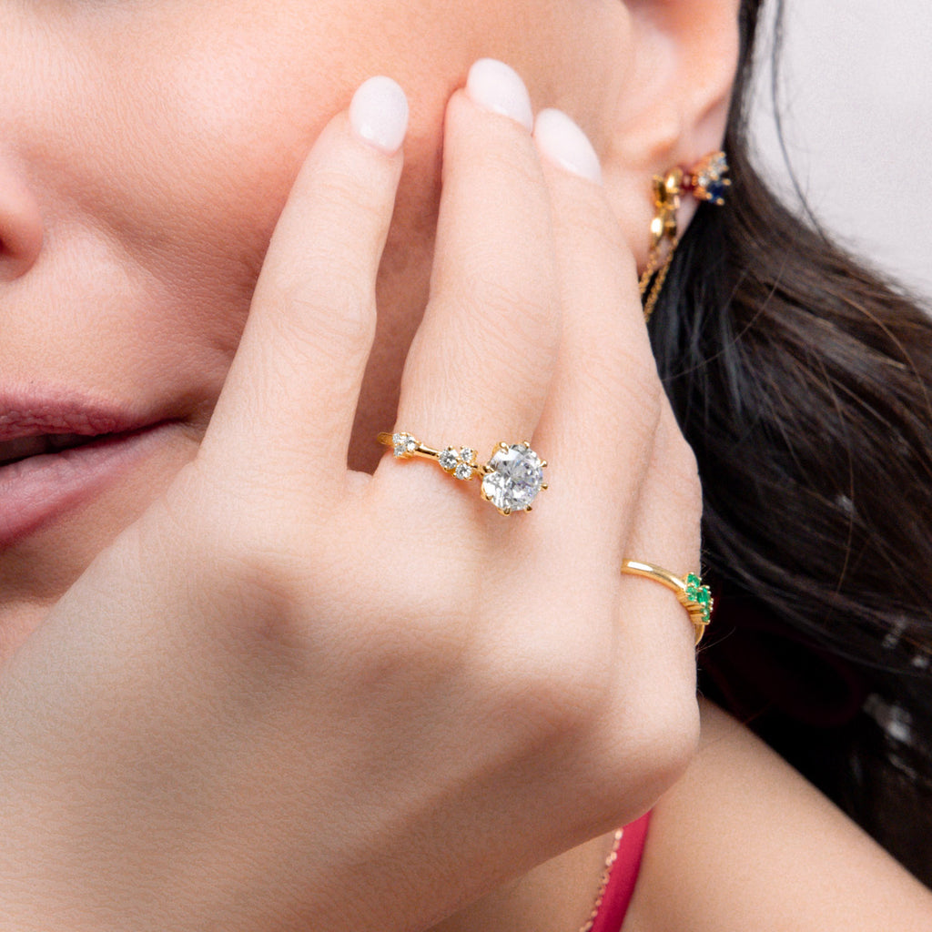 Model wearing Ecksand's Eight-Prong Blossom Engagement Ring with Side Diamonds in 18k Yellow Gold, Round