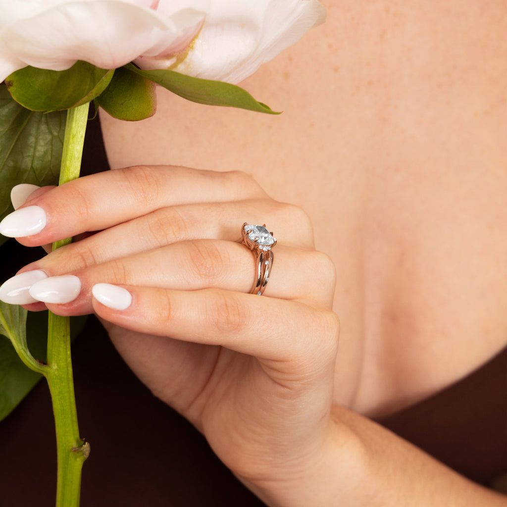 Model wearing a Canadian-made pear-cut diamond engagement ring with a split shank band in 14K rose gold.