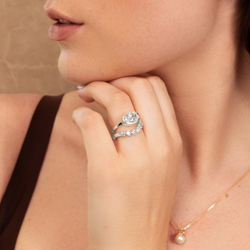 A model wears Ecksand's Canadian-made oval diamond engagement ring and wedding ring set in 18K white gold.