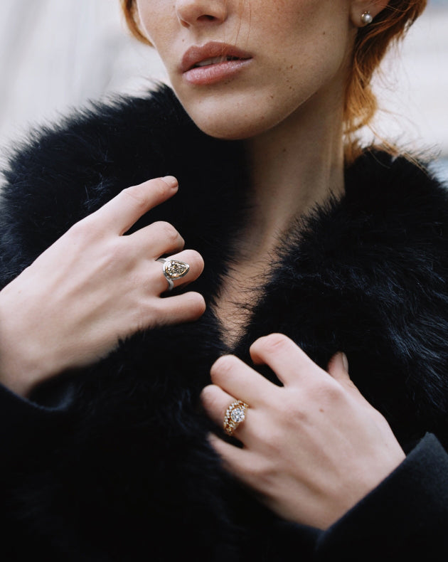 model wearing canadian-made ecksand diamond engagement rings in 18k white and yellow gold with white and colourless diamonds and wedding ring with interlocking pave band