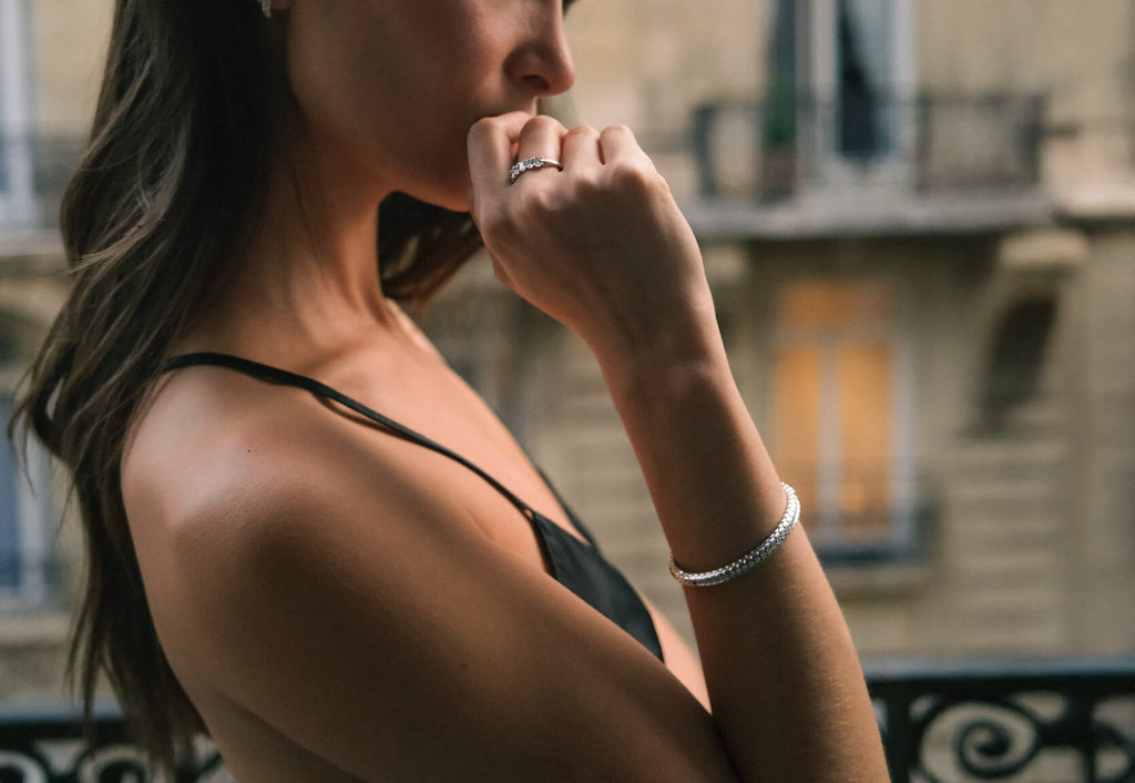 model wearing canadian-made 18k white gold diamond fine jewelry bangle bracelet and oval diamond ring