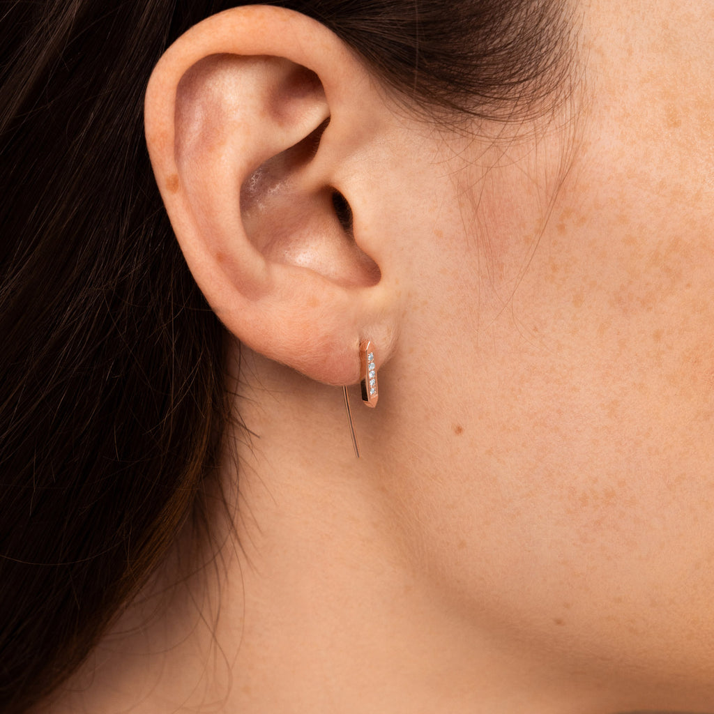 A model wears a Canadian-made Ecksand dangle earring in 14K rose gold with pavé diamonds.