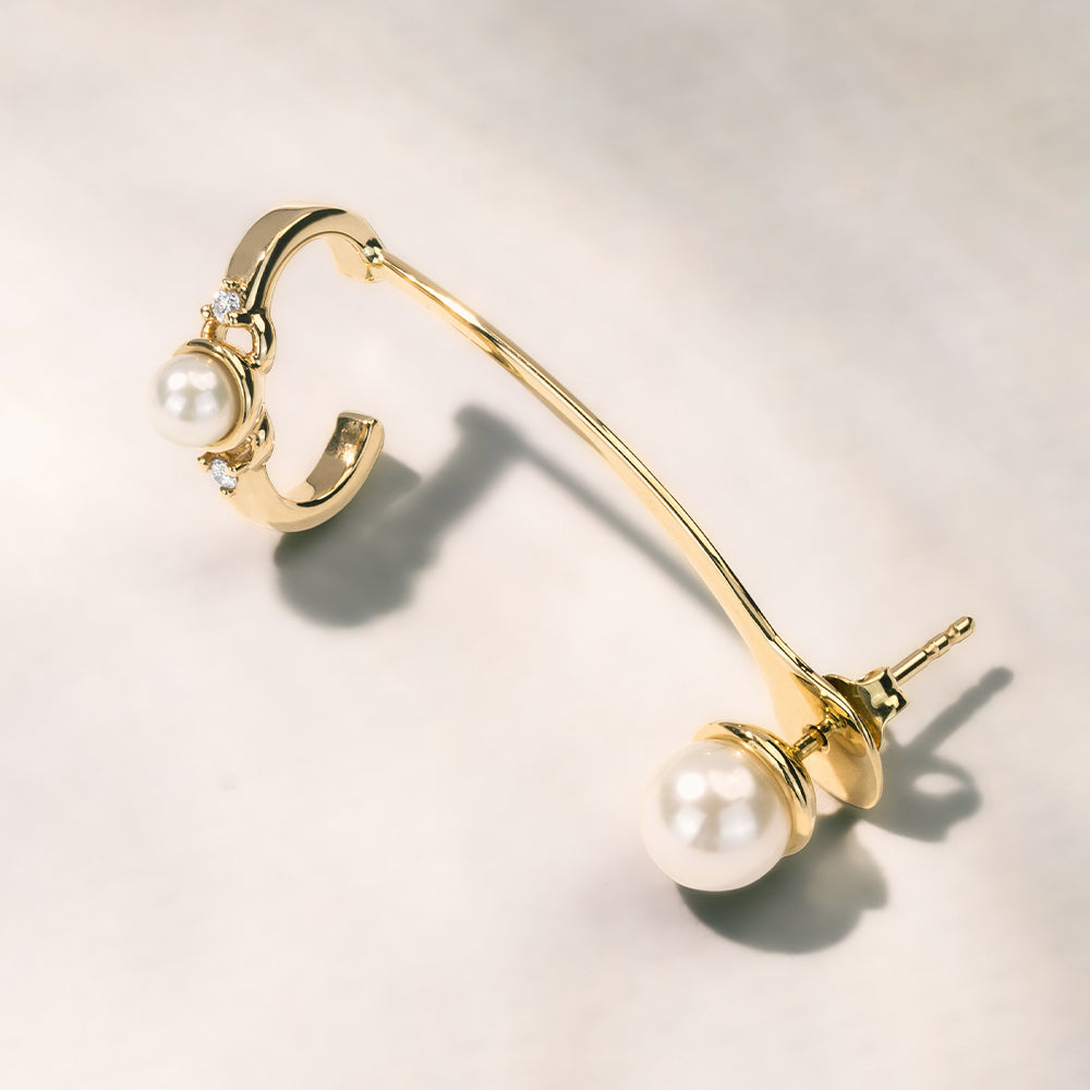 18k Gold conch stud earring with akoya pearl on a light background