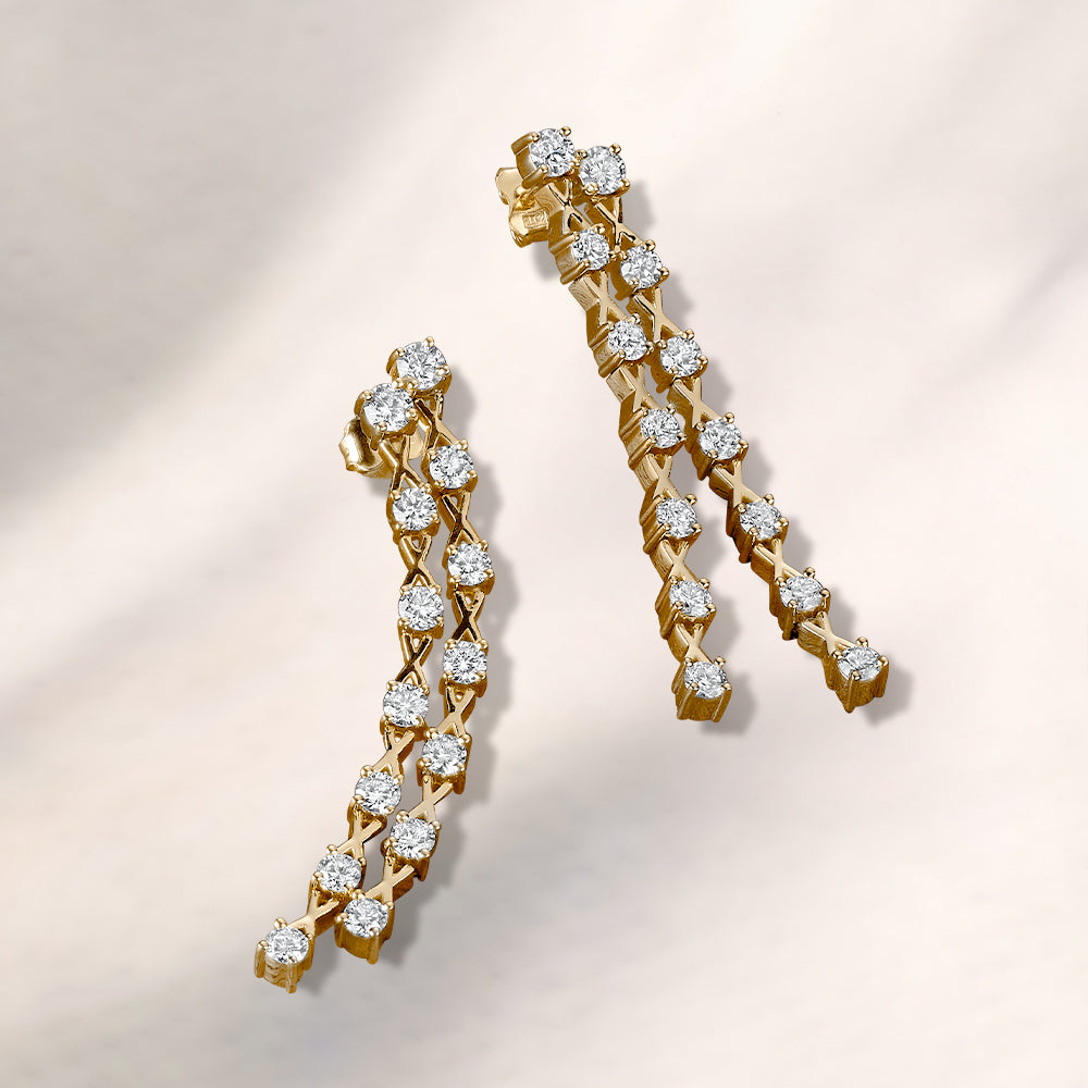 Gold earrings with diamond accents on a light background