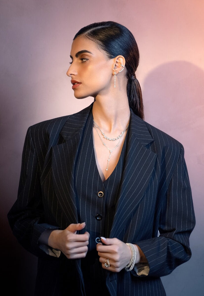model wearing white gold diamond jewelry from the ecksand starlight collection on a pink background