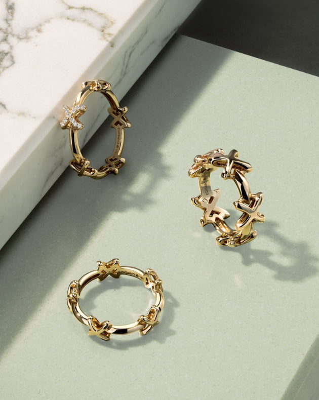three 18k yellow gold rings from ecksand's mark collection made in canada on a green background