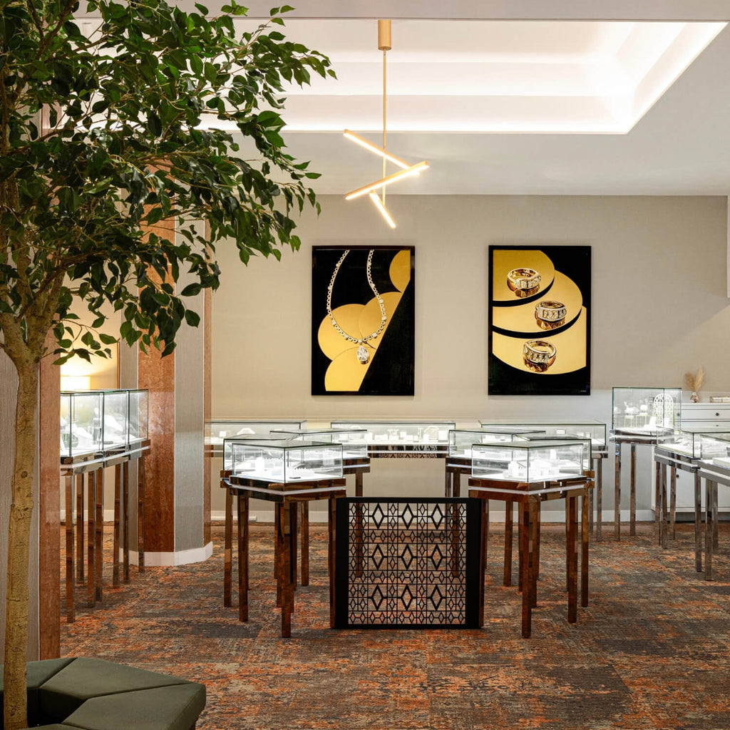 Interior of Ecksand’s jewelry boutique featuring glass display cases, elegant lighting, and framed artisan photography on the walls.