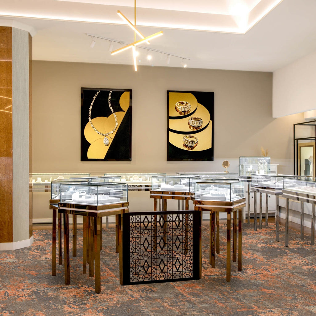 Interior of Ecksand’s jewelry boutique featuring glass display cases, elegant lighting, and framed artisan photography on the walls.