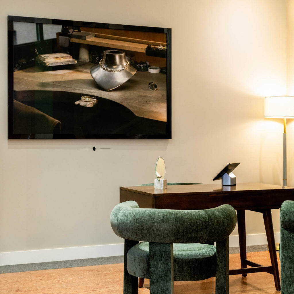 Interior of Ecksand’s jewelry boutique featuring glass display cases, elegant lighting, and framed artisan photography on the walls.