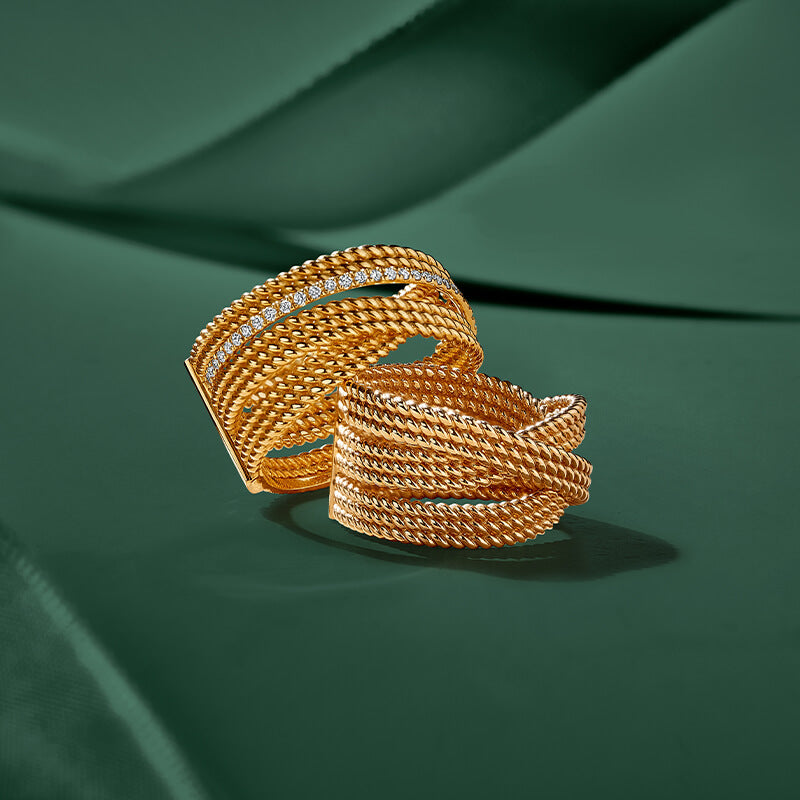 ecksand yellow gold twisted rings on green background