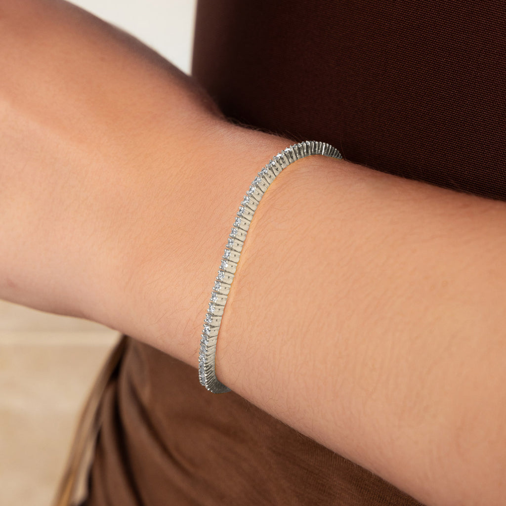 Close-up of a model wearing a Canadian-made Ecksand diamond tennis bracelet in 18K white gold.