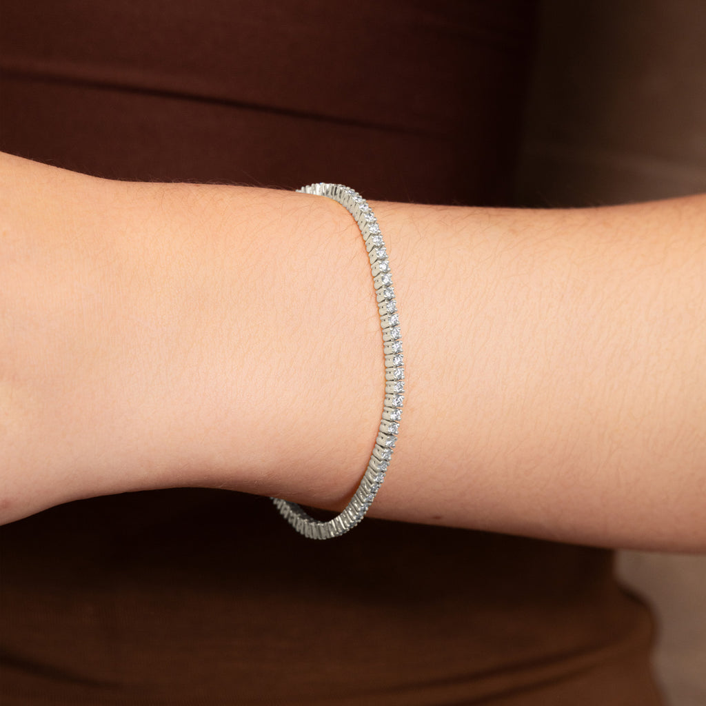 A Canadian-made diamond tennis bracelet in 18K white gold from Ecksand worn on a wrist.