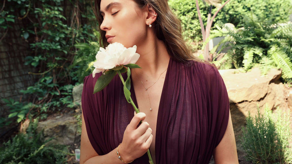 Ethical Fine Jewelry - model wearing Ecksand diamond rings and fine jewelry with a yellow gold bangle bracelet and akoya pearl jewelry