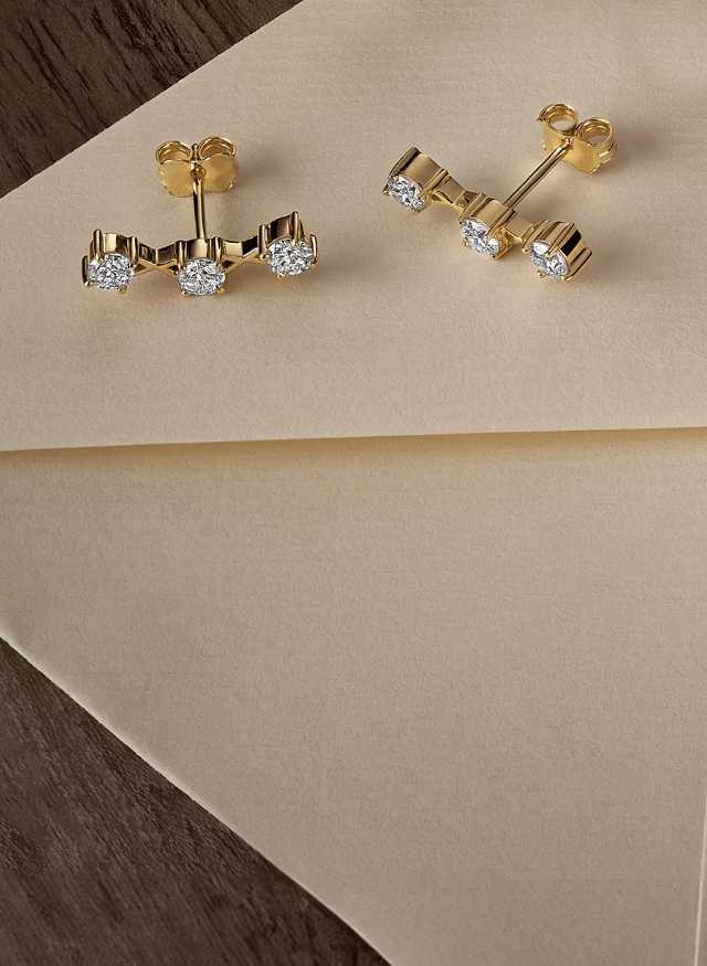 canadian-made ecksand 18k yellow gold diamond crawler stud earrings on a beige background