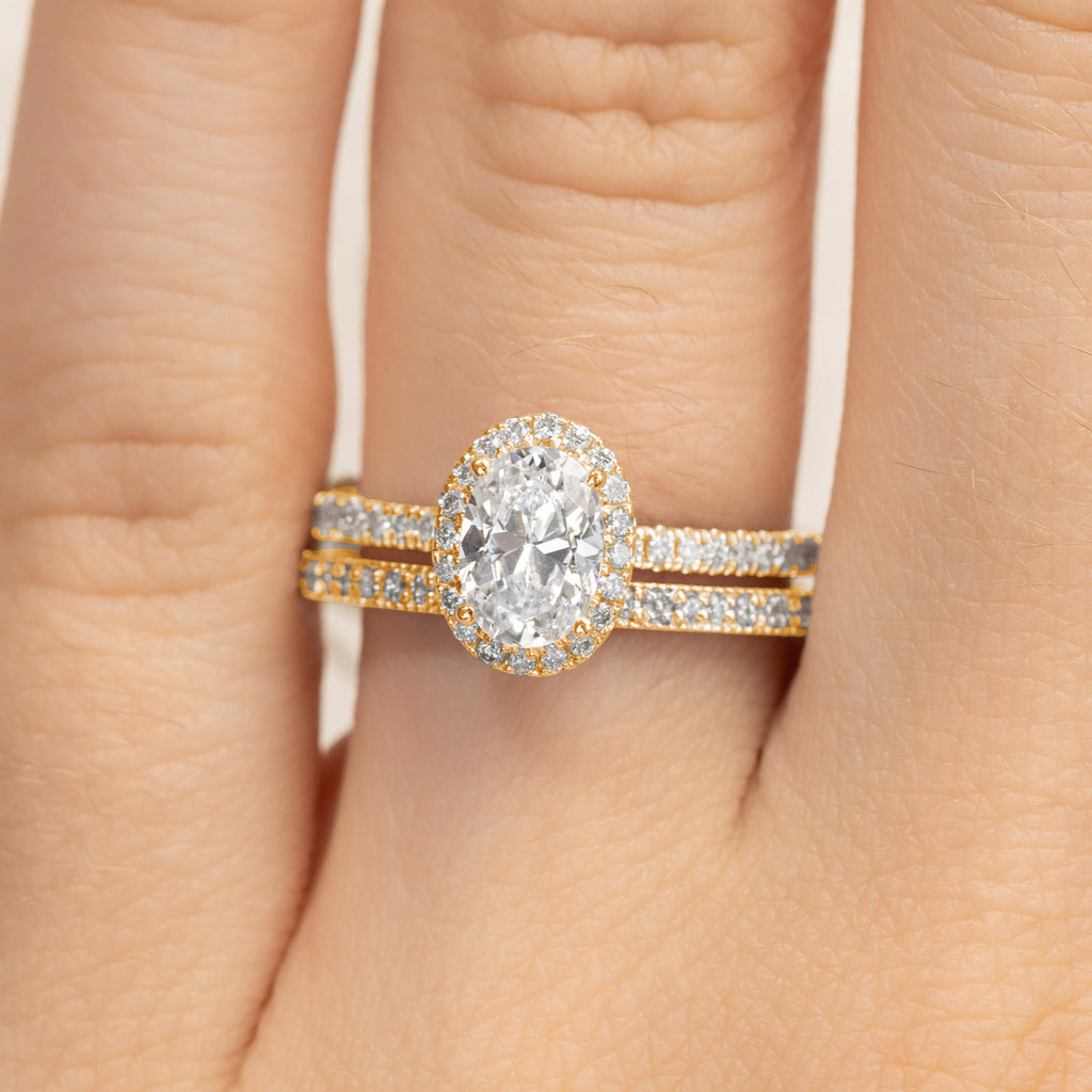 Ecksand oval halo diamond engagement ring and wedding band set in two-tone 18K yellow and white gold. Canadian-made.